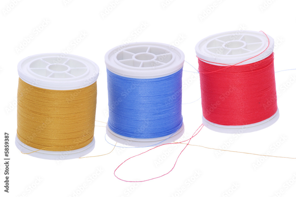 three plastic spools of colored yarn three plastic spools of colored yarn