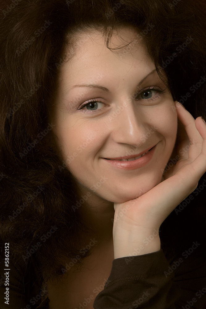 Portrait of the young smiling woman on a dark background. Portrait of the young smiling woman on a dark background.