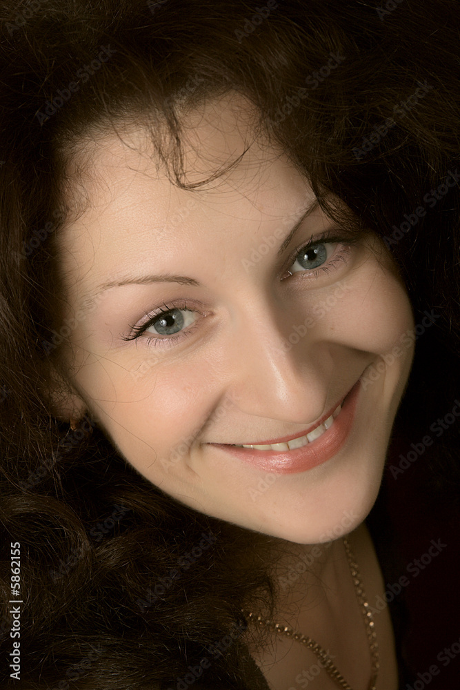 Portrait of the young smiling woman on a dark background. Portrait of the young smiling woman on a dark background.