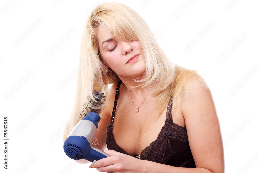 The young woman stacks hair by means of a hair drier The young woman stacks hair by means of a hair drier