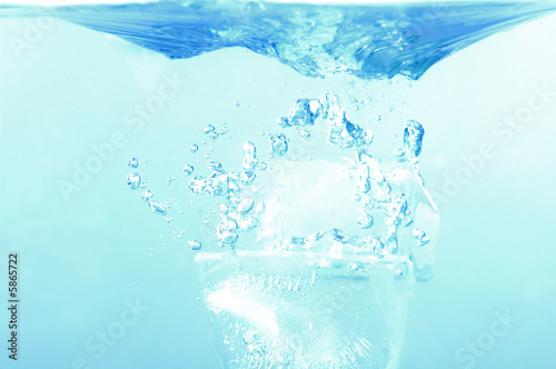 Ice cube fall in the water - refreshing splash .