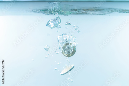 Photo of Coins sinking in the water .