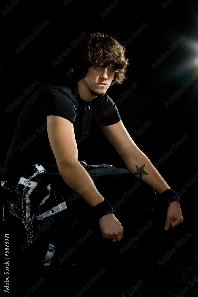 An alternative styled young man posing over black. An alternative styled young man posing over black.