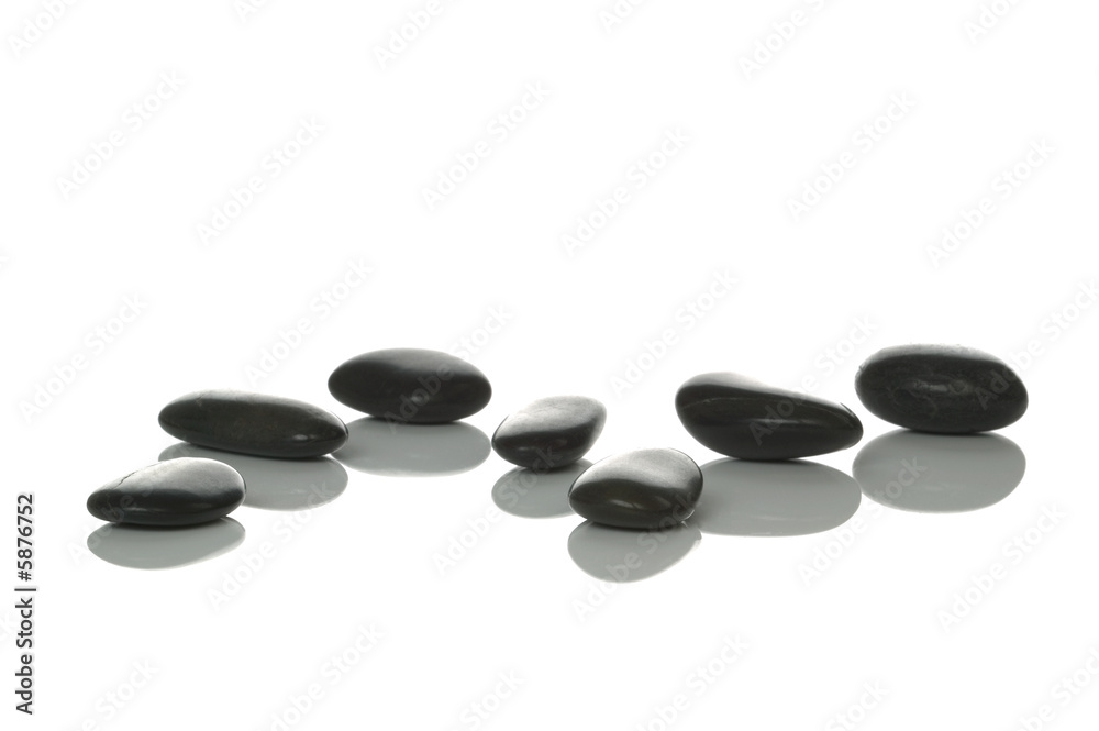 Seven black pebbles with reflections on a white background Seven black pebbles with reflections on a white background