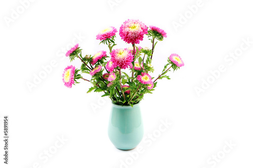 Vase of pink and yellow flowers isolated on white.