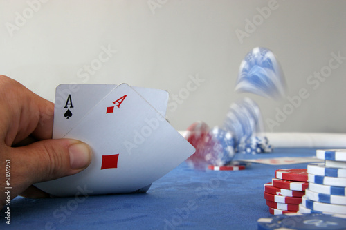 Canvas Print A poker player holds two aces and throws chips on the table
