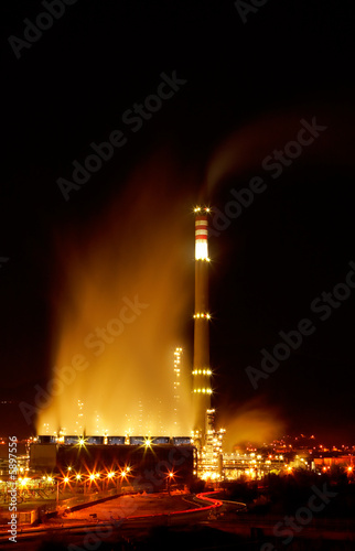 View of a petrochemical refinery with chimneys and storage tanks