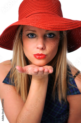 Beautiful young girl with red hat blowing a kiss