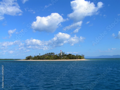 Coral island in a ble sea whith blue sky and white couds behind © Nigel Monckton