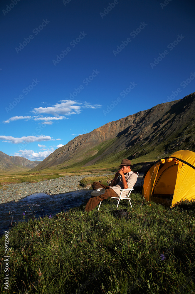 Man sitting in the chair at the camp Man sitting in the chair at the camp