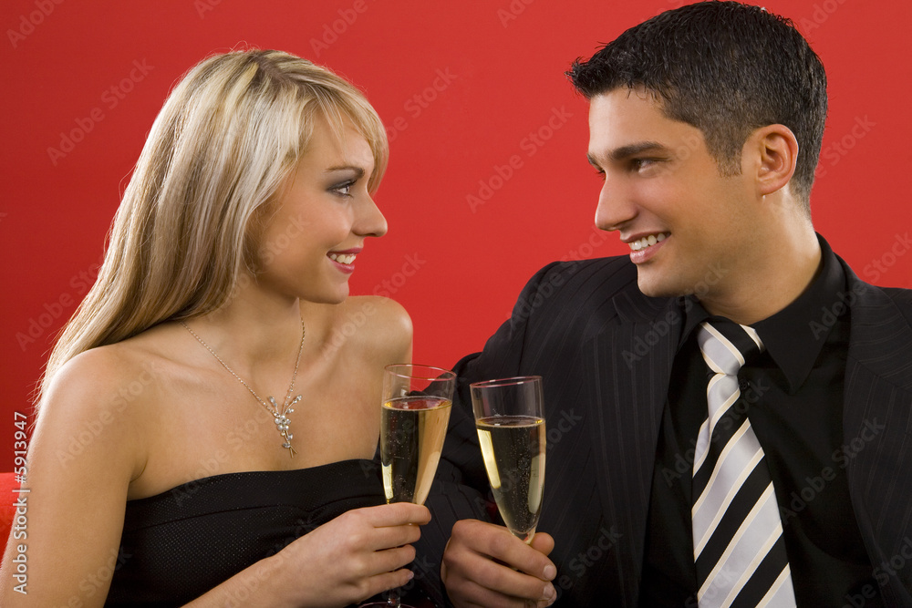 Young couple sitting on couch and rising toast. Young couple sitting on couch and rising toast.