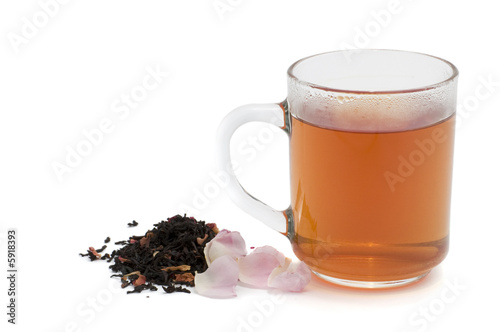 cup of tea, tea leaves and wild rose on white