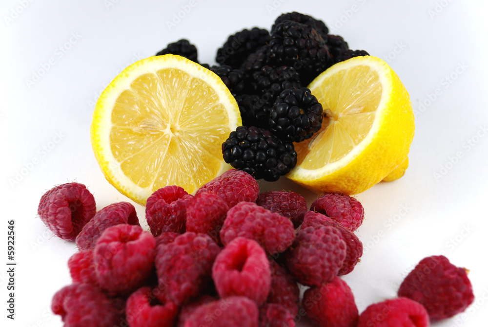Lemon with black berries and raspberries on a white back ground Lemon with black berries and raspberries on a white back ground