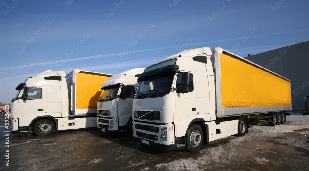 Three yellow trucks on the parking