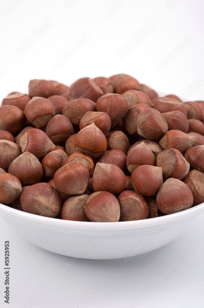 Fototapeta premium Hazelnuts on a white bowl. White background