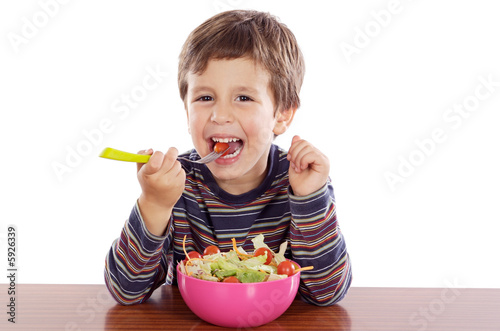 Child eating salad a over white background