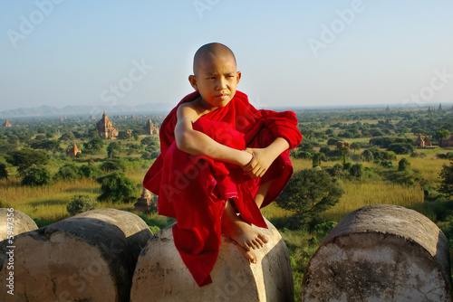 young buddhist monk on temple background photo