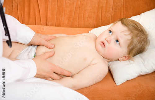 Doctor pediatrician exam baby abdomen . Close-up.