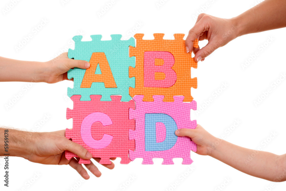 hands holding puzzle with ABCD letters isolated on white hands holding puzzle with ABCD letters isolated on white