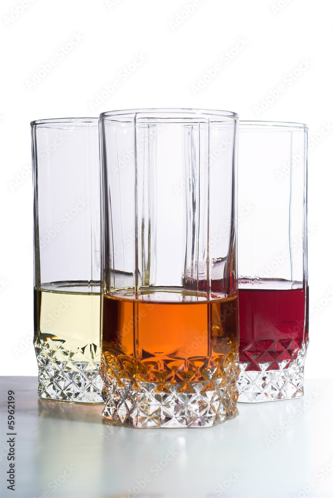 Three glasses with drinks on table. Isolated on white Three glasses with drinks on table. Isolated on white