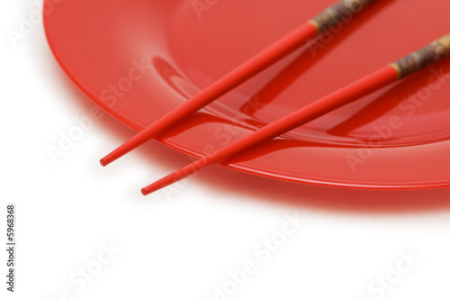 Red plate and chopsticks isolated on the white