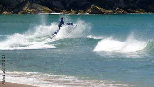 jetskier jumps jetski wave beach sending spray foam in air