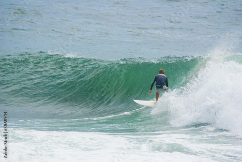 surfer surfs large ocean wave