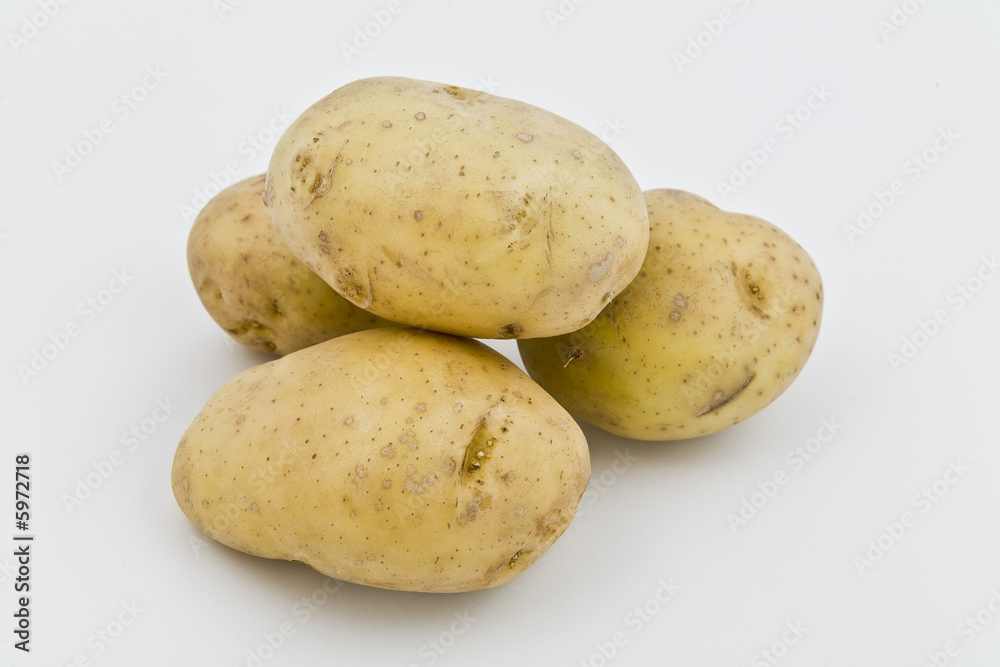 four young potatoes with gentle shadow on natural background four young potatoes with gentle shadow on natural background