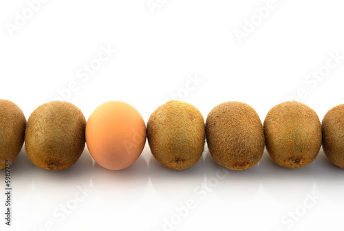 One egg in a row of kiwis. White background.