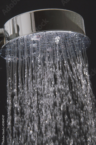 A close-up image of water running from a shower head.