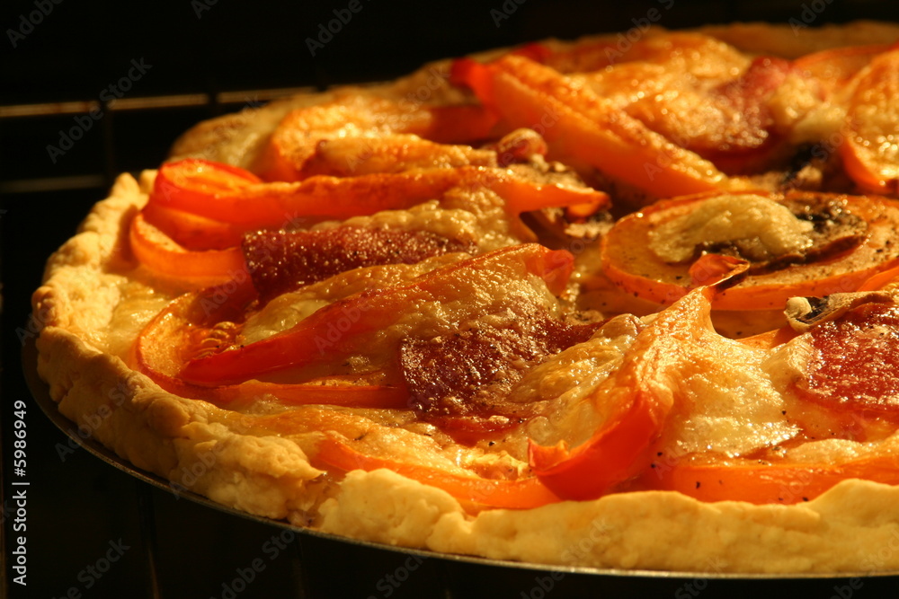 Baking a pizza - tart - with tomatoes, mushrooms, salami