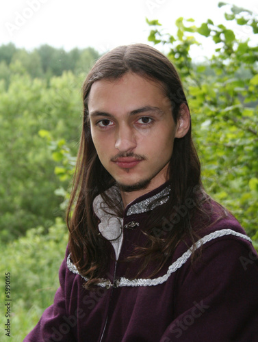 Portrait of the romantic youth in summer forest