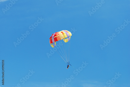 Parasailing in clear blue sky
