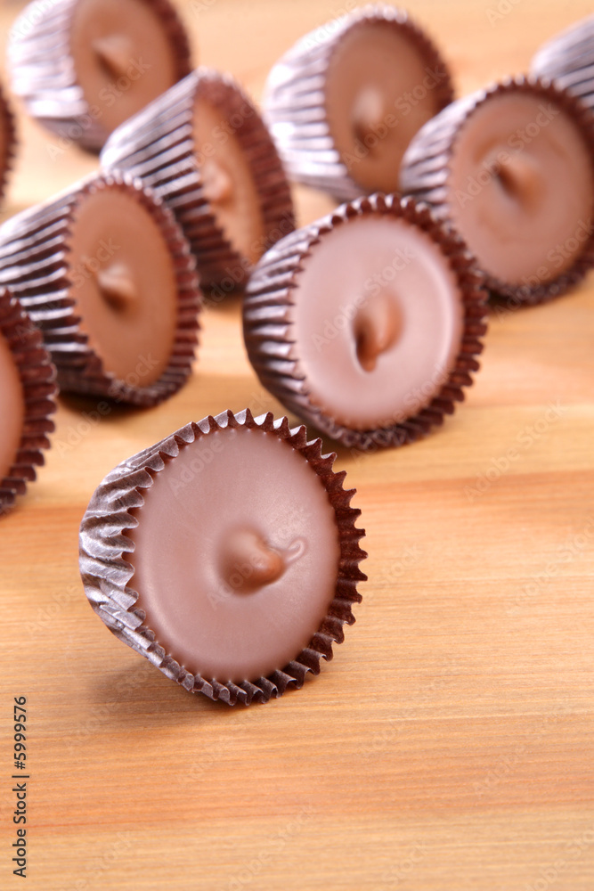 A group of peanut butter cups on a wood counter top.
