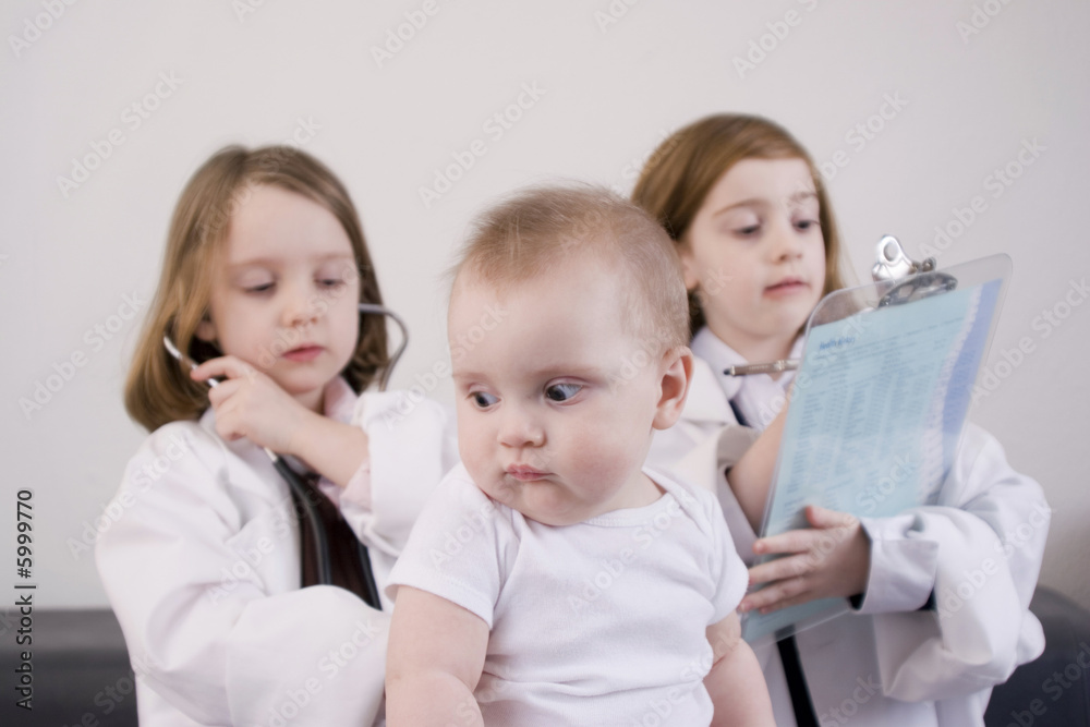 Three little girls playing doctor in a doctor's office. Three little girls playing doctor in a doctor's office.