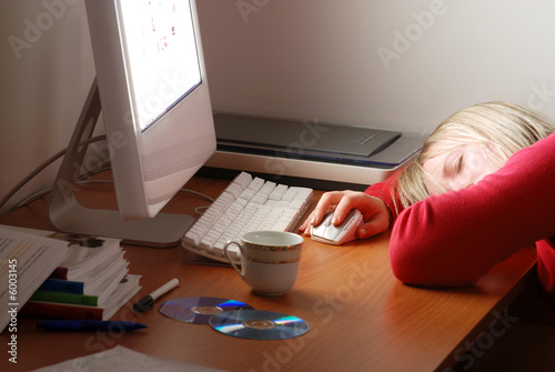 ragazza dorme davanti a computer photo