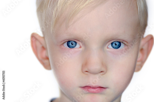 Portrait of a serious boy s part of face with blue eyes