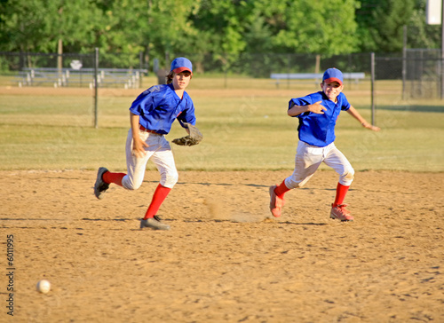 Two Boys in Uniform Running for the Ball