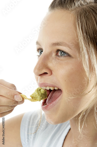 Frau isst chips mit guacamole