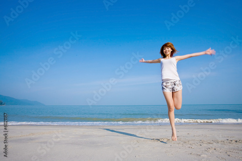 a young woman by the beach happy jumping
