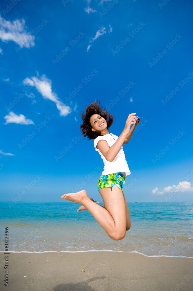 young beautiful girl jumping happily at the beach young beautiful girl jumping happily at the beach