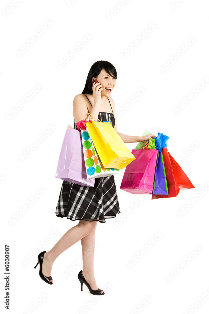 A woman carrying shopping bags and talking on cell phone