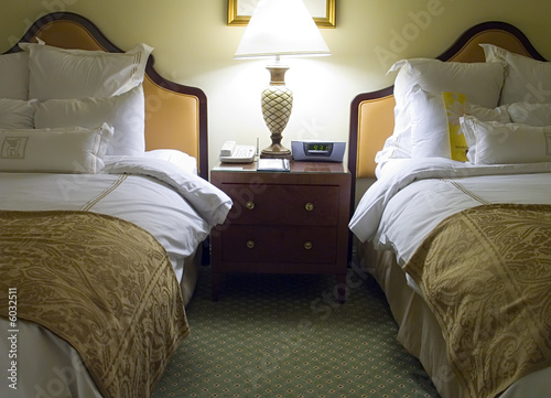 Vászonkép Two beds bedroom with bedside table and lamp