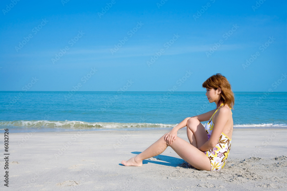 woman wearing floral swimsuit relaxing by the beach