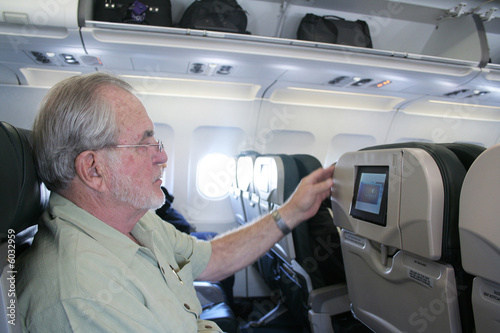 Man on airplane looking at inflight tv photo