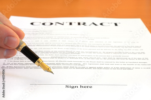 Hand pointing at signature place on a contract document