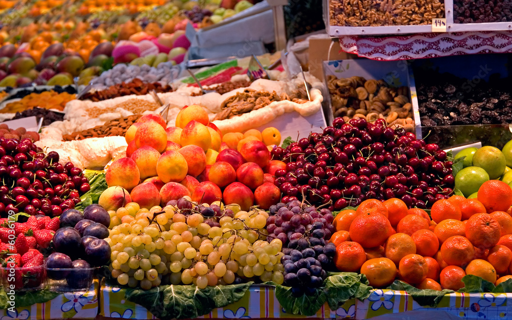 A street market with a huge range of fruits and nuts for sale.