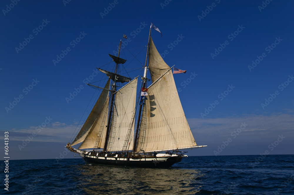 Sloop at sea under full sail on a calm day