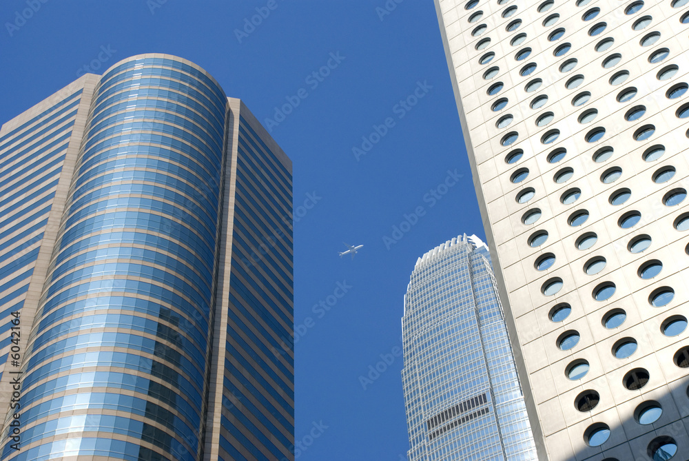 a plane flys past hong kong sky scrapers