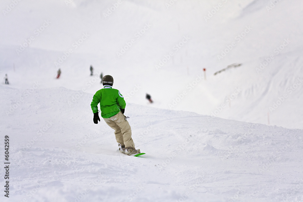 jeune snowboarder descendant une piste de ski à la neige